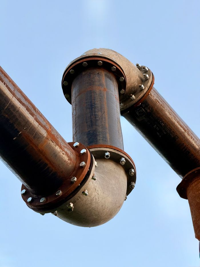 Crafting Captivating Headlines: Your awesome post title goes here Close-up of large industrial pipes with bolts on a clear day.